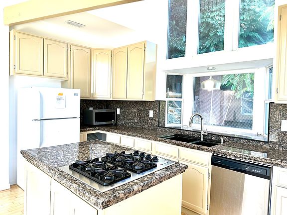 Kitchen has stovetop, oven & dishwasher.