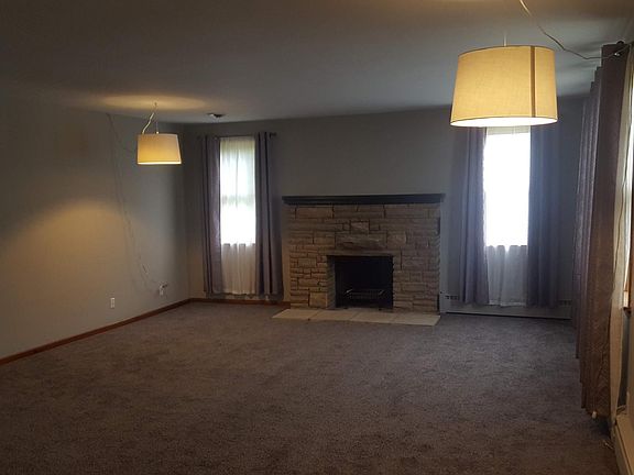 Large living room with new carpet and fireplace.