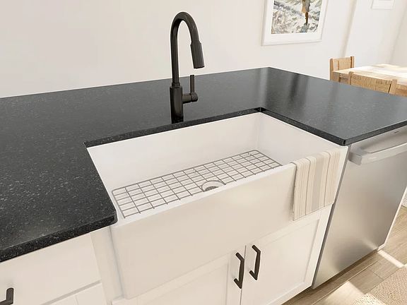 Kitchen with white apron-front sink and matte black fixtures