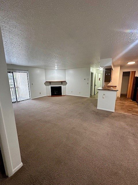 View of living room, galley style kitchen, entry hallway