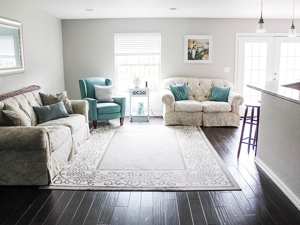 Main Living Room with open concept to dining area, kitchen, and french doors leading to the private backyard