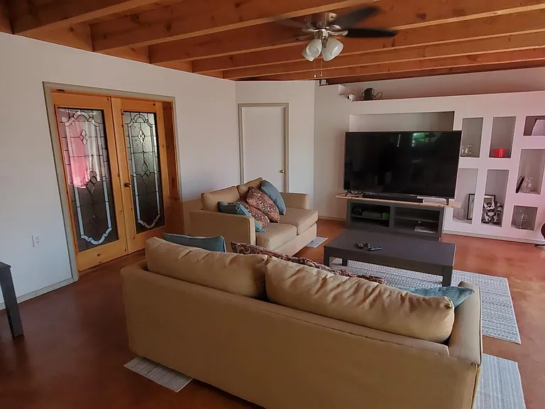View from Dining Room to Living Room, door to rear patio on right, and Stain Glass doors on left to Master Suite