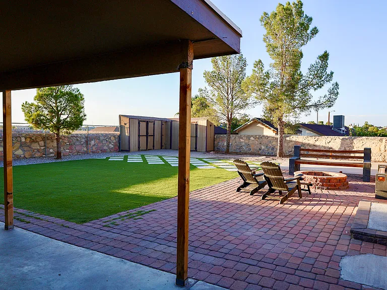 Spacious low maintenance backyard with turf, mature trees and fire pit. One storage unit available.