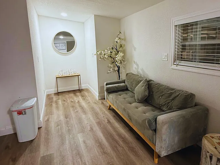 Spacious sofa with decorative pillows, elegant mirror and accent table.
