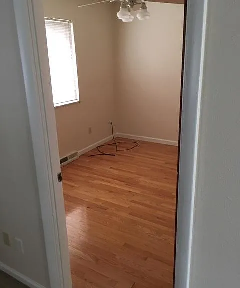 2 bedrooms that have hardwood floors and ceiling fans.
