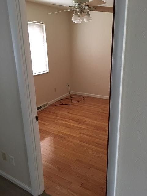 2 bedrooms that have hardwood floors and ceiling fans.