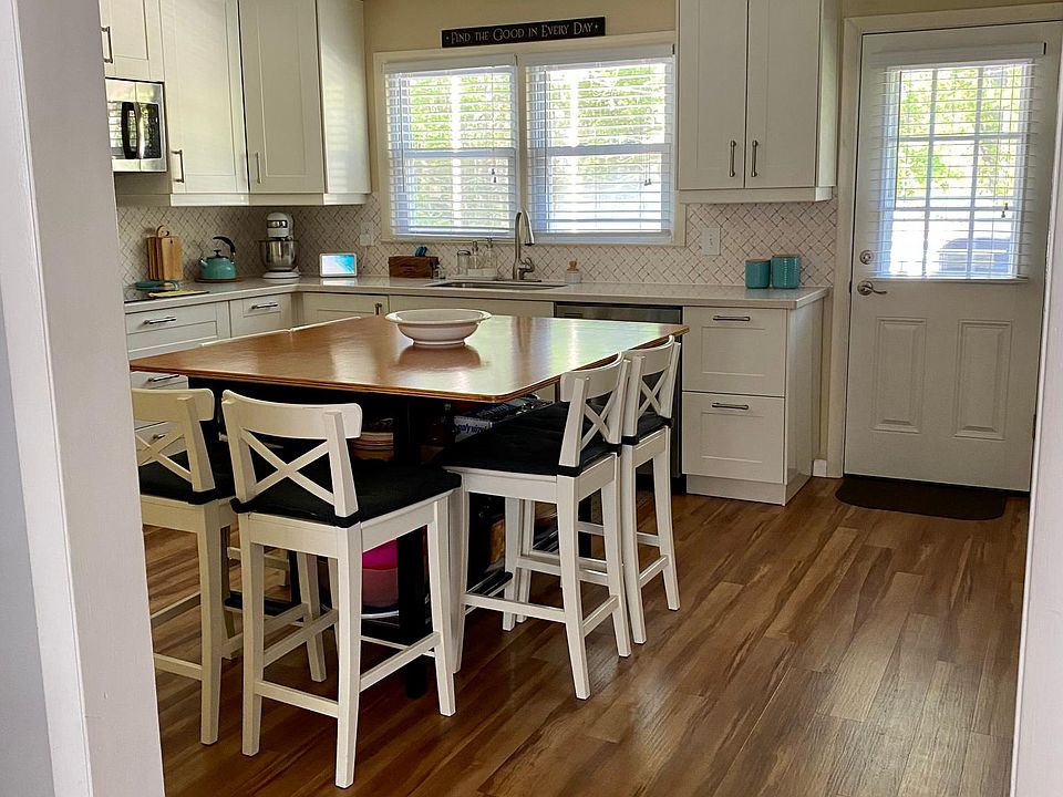 Bright kitchen leads to deck and backyard