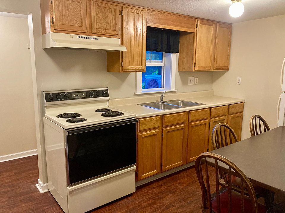 Kitchen includes electric stove/oven, refrigerator, and table with four chairs (optional).