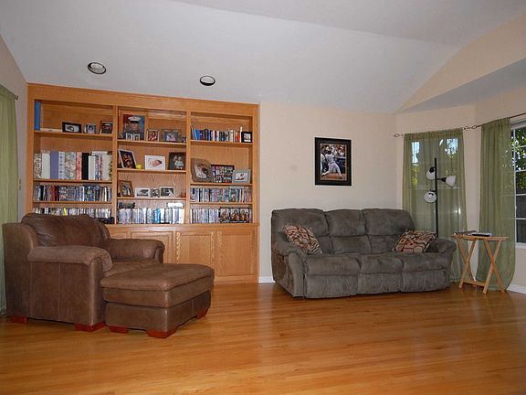 living room with raised ceilings and built in bookcase