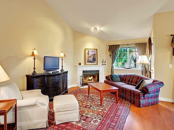 The living room has vaulted ceilings, wood burning fireplace and lots of windows.