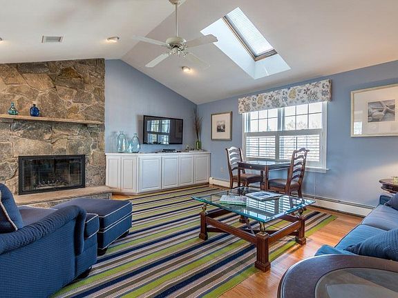 Vaulted living room ceilings with skylights and a wood-burning fireplace