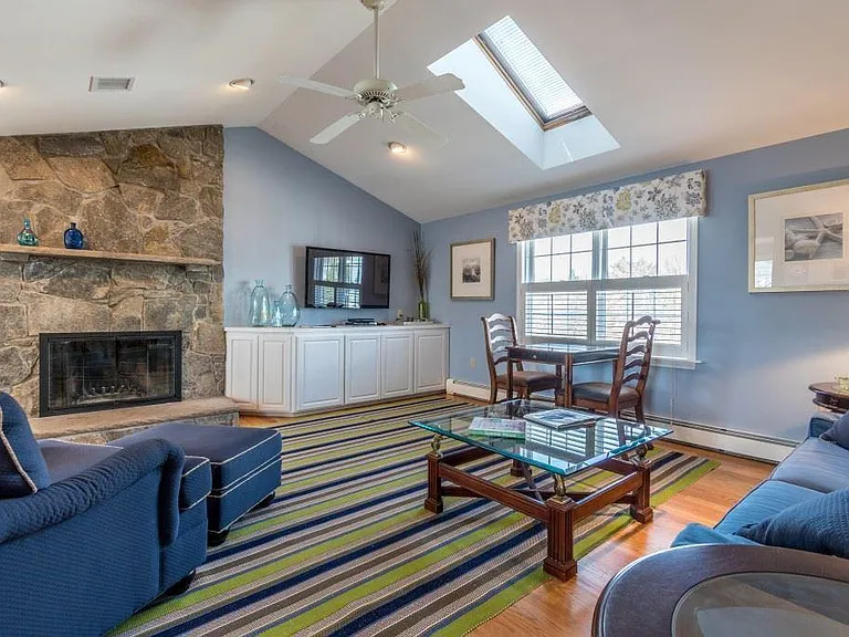Vaulted living room ceilings with skylights and a wood-burning fireplace