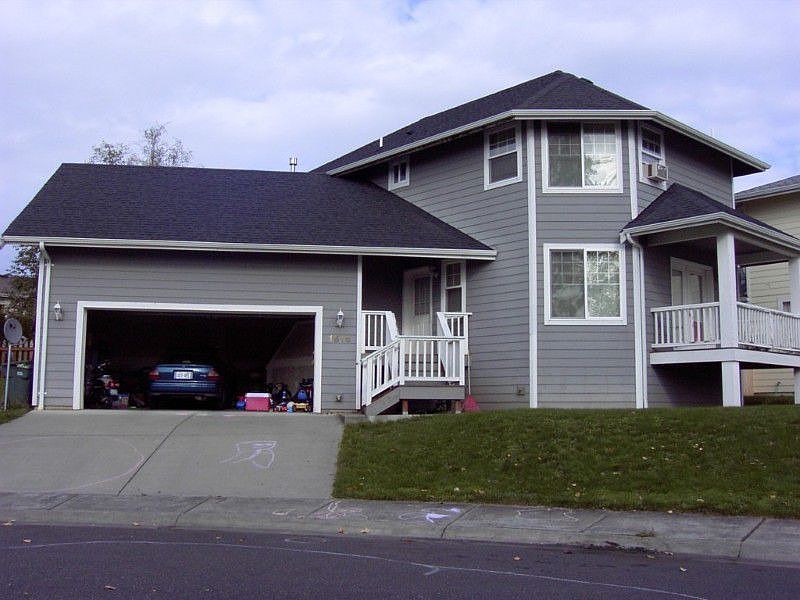 Front of the home with large garage open.