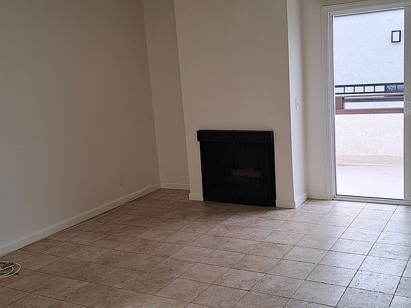 LIVING ROOM NEXT TO KITCHEN WITH SLIDER TO BALCONY AND FIREPLACE