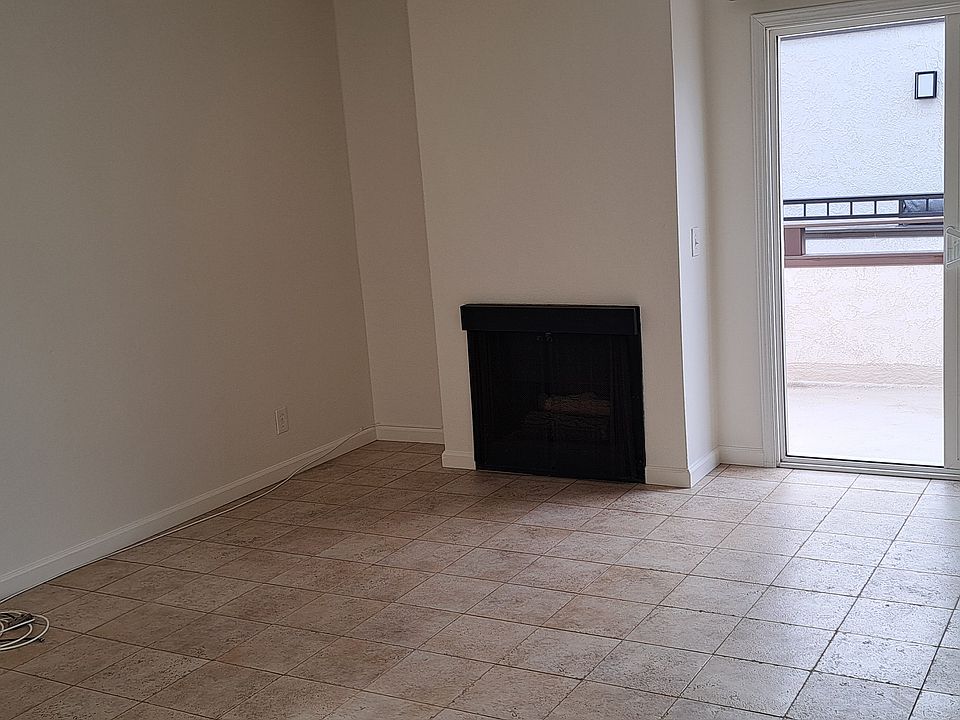 LIVING ROOM NEXT TO KITCHEN WITH SLIDER TO BALCONY AND FIREPLACE
