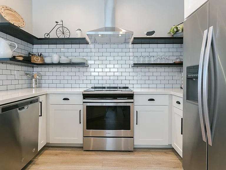 Floating shelves and new stainless steel appliances make this fully equipped kitchen a joy to cook in!