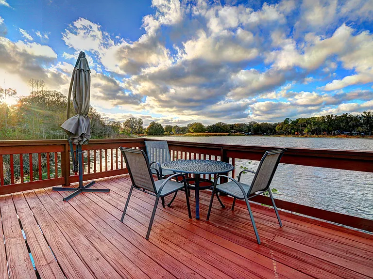 Large pier for fishing or relaxing, with table, chairs and large sun umbrella