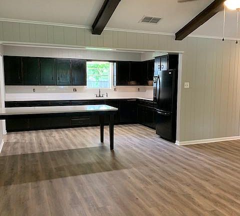 View from part of the living room, into the dining area and kitchen. All new floors. Dining table seats 9.
