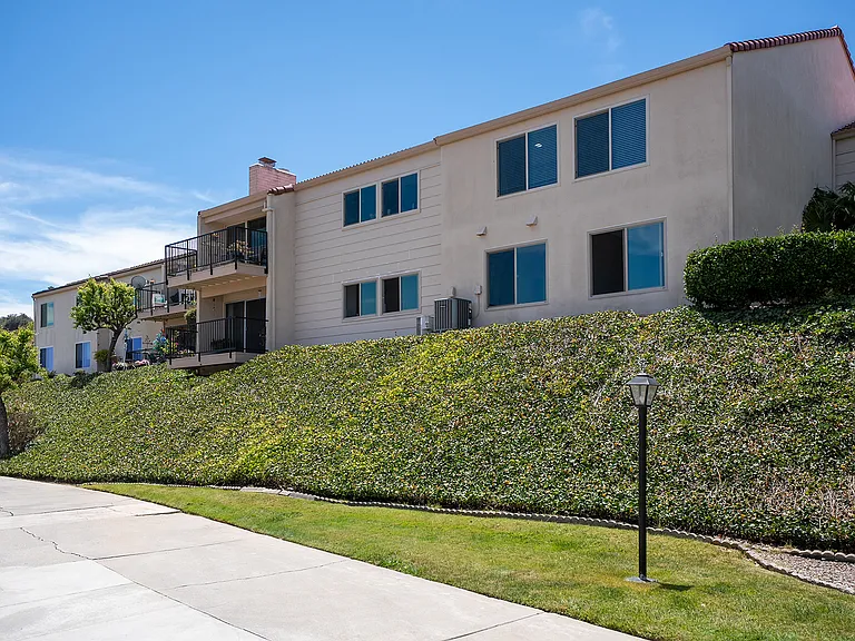 Covered patio overlooking ample greenspace between condominium units.