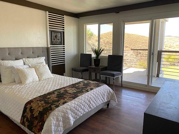 Large master bedroom with balcony overlooking to the lagoon in the backyard