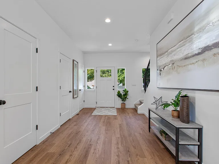 Large open entryway with easy access to storage closets and downstairs bathroom.