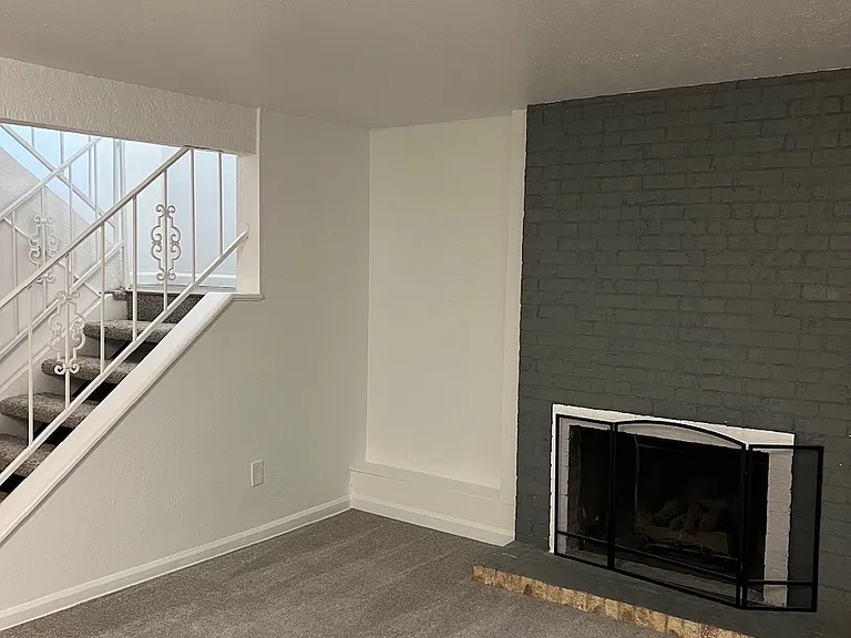 Large, open basement with fireplace.