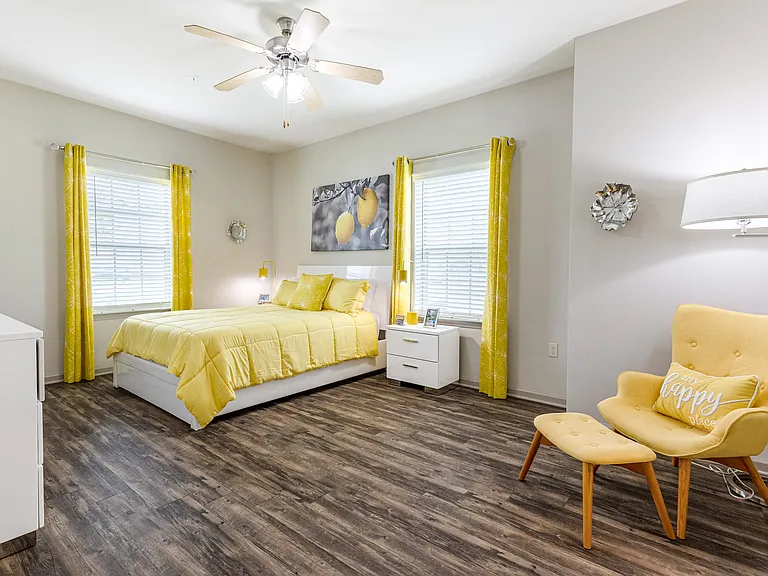 Spacious bedroom with windows and wood-designed flooring