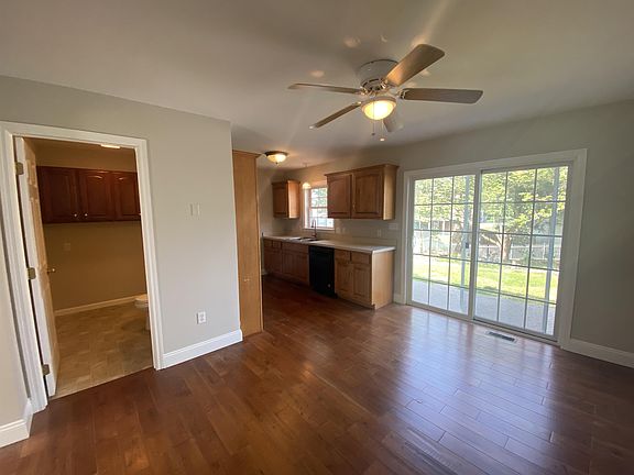 Large dining room kitchen combination with real hardwood flooring opening to private patio