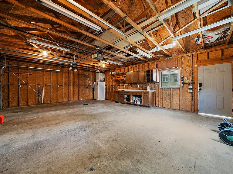 garage interior. Door in front to the backyard. Parking for lower unit to the far left