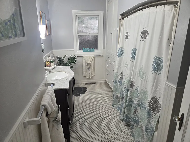The main floor is home to a large full bathroom, featuring a classic shower with tub