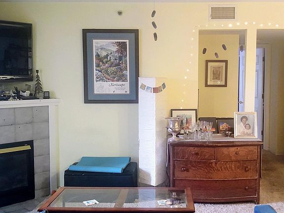 The living room has a cozy fireplace and a unique peek-thru detail.
