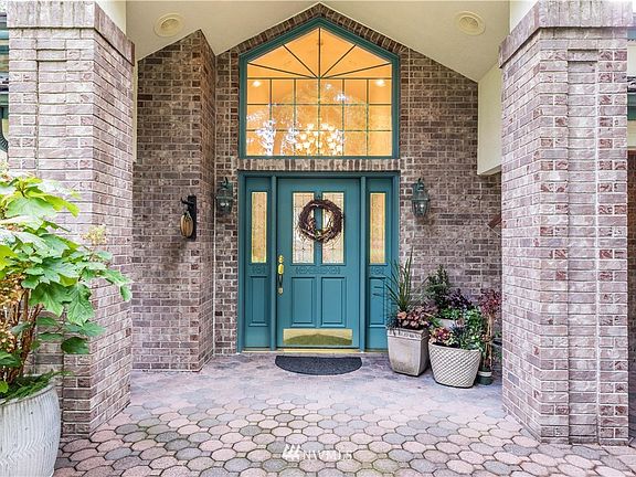 grand entry with vaulted ceilings and brick