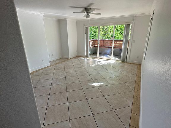 Living room with tile floor and direct access via sliding door to the front balcony.