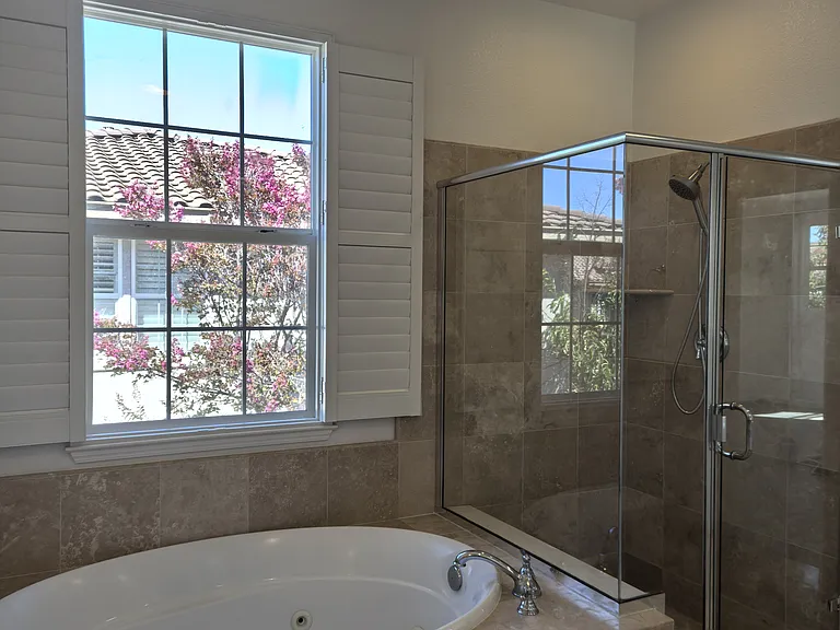 Primary suite featuring a spacious bathroom with a Jacuzzi soaking tub, creating a private spa-like retreat