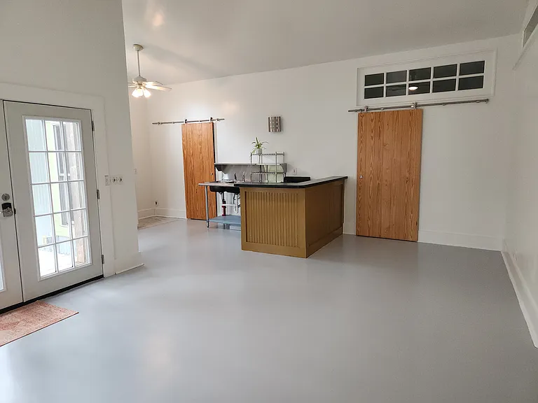 Additional view of living / dining / kitchen area; pantry door (with w/d hookup) / back door out to porch, yard and parking area