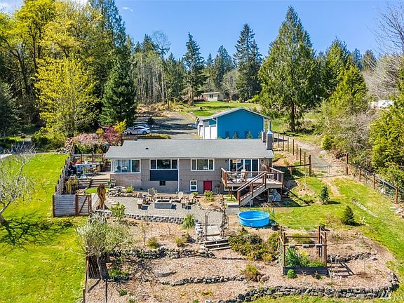 Water front facing side of home. Fire pit, deck and graden