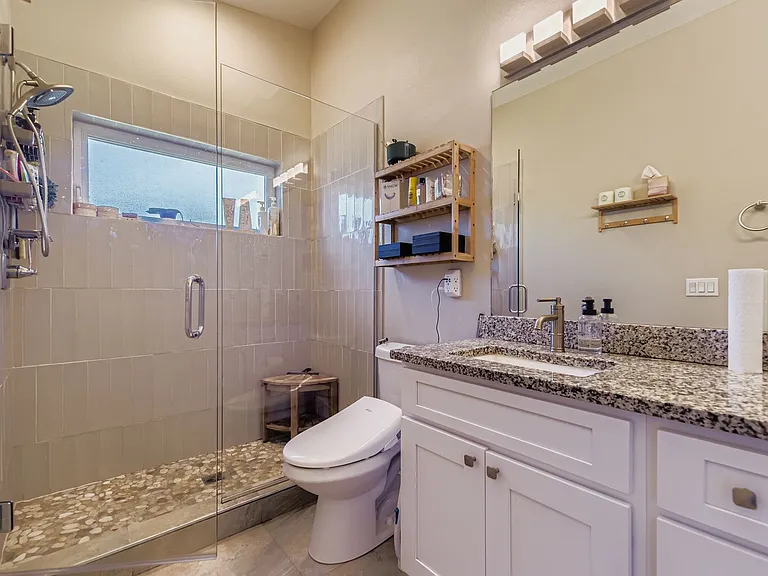 Private bathroom in primary bedroom with custom shower with bidet toilet cover