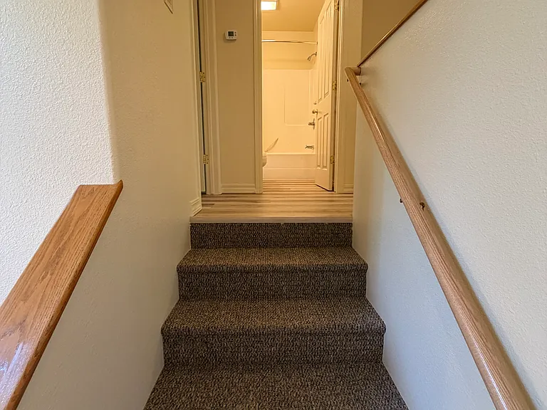 Stairs leading from the front door to the three upstairs bedrooms.
