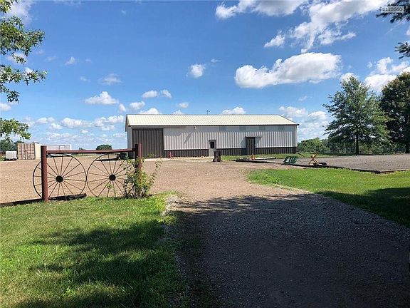 Barn 2 with 4 horse stalls, paddock, shop with concrete floors, tack room, wash bay, and sink.  Outdoor riding arena with pulverized rubber and sand on the right here.  Could be used for a volleyball game also.  Both barns are plumbed with drains.  Several (5) frost free water hydrants scattered conveniently on property.  Fence and cross fence.