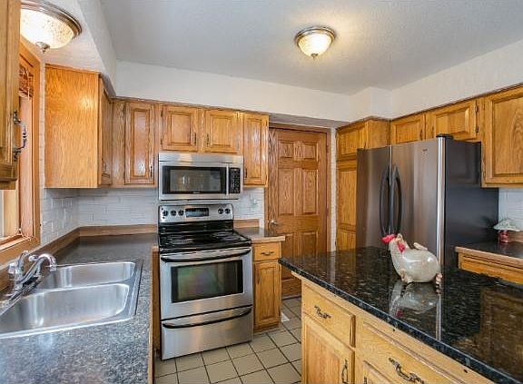 Stainless Appliances, tile floor open to formal dining room.