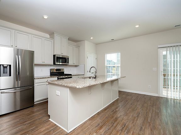 Spacious kitchen with large refrigerator, chef-style gas stove and oven, microwave oven, and dish washer. Large island with granite countertops.