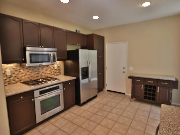Mobile island with granite top and vine rack included. Door enters to the gargage