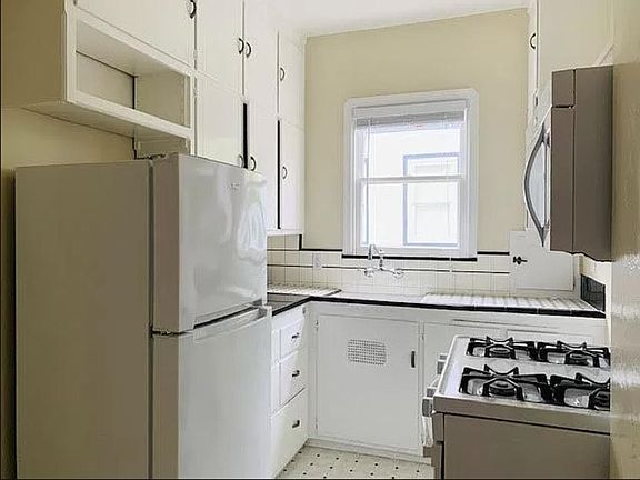 Gorgeous kitchen with updated appliances, gas stove, and vintage black and white tile, and new black marble countertop