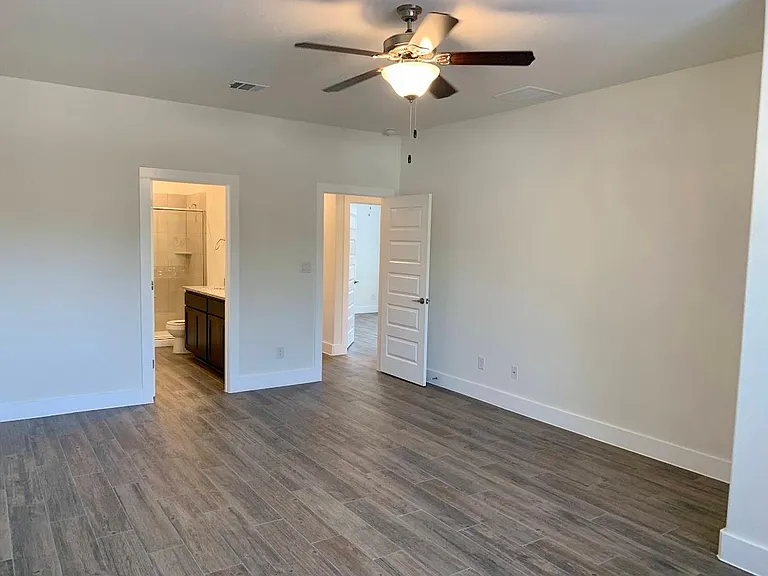 Large main bedroom has on suite bathroom and ceiling fan.