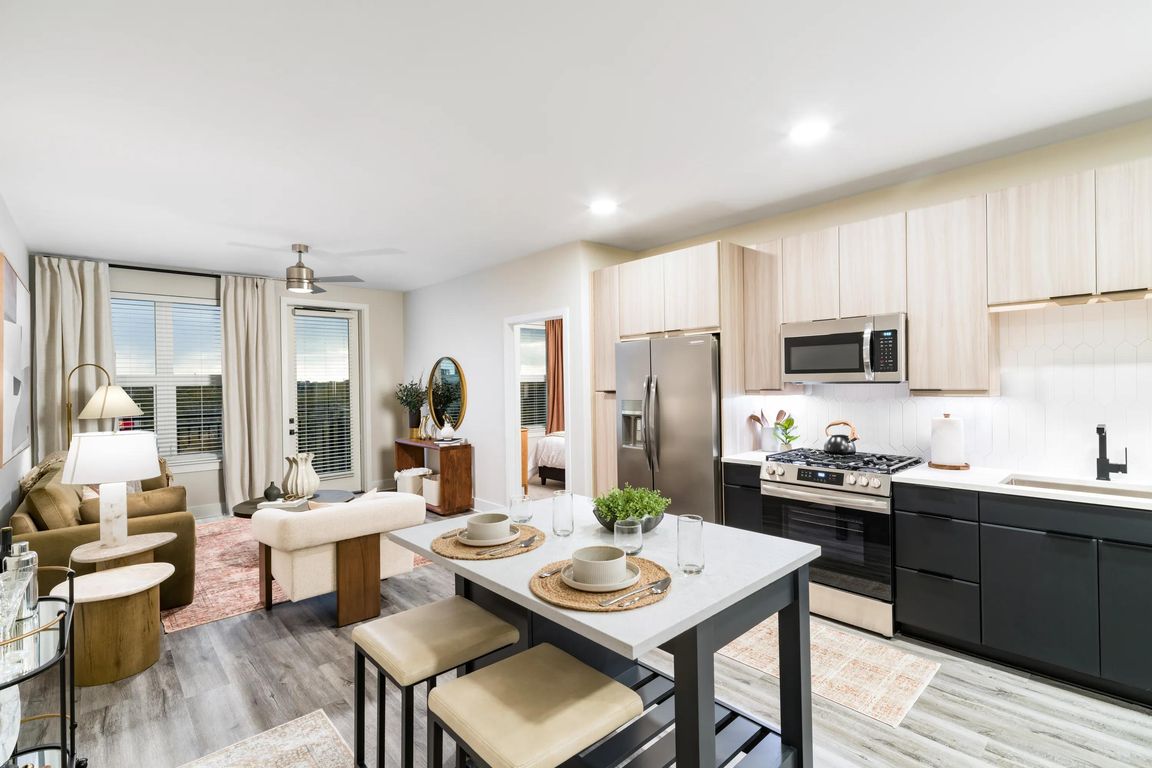 An open-concept apartment home with a central island, streamlined kitchen, and connected living areas designed for everyday flow and flexibility.