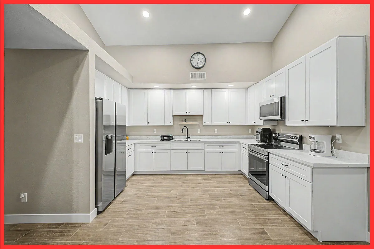 Spacious U-shaped kitchen with ample white cabinetry, generous counter space, and stainless steel appliances for easy meal pr - E Princess Dr