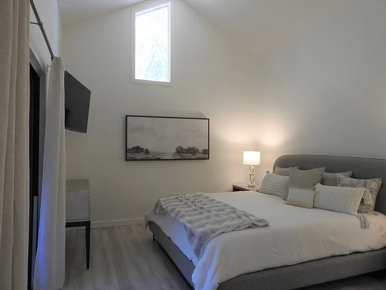 Primary bedroom with King bed and premium bedding on top-of-the-line Nectar mattress. Vaulted ceilings add spacious ambience.