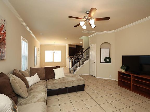 ANOTHER GORGEOUS VIEW OF THE HIGH CEILINGS AND OPEN-CONCEPT FAMILY ROOM INTO DINING AREA - It's hard to miss the upgraded features into the arched built-in, crown molding, & rod iron stair case spindles.