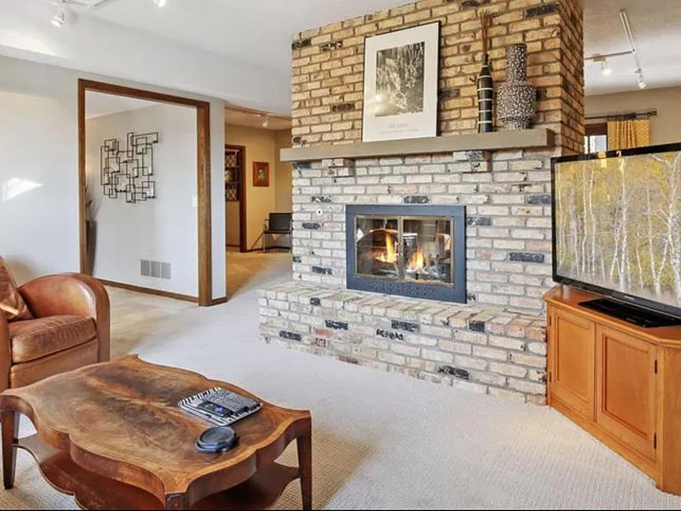Lower level rec room with double-sided wood fireplace