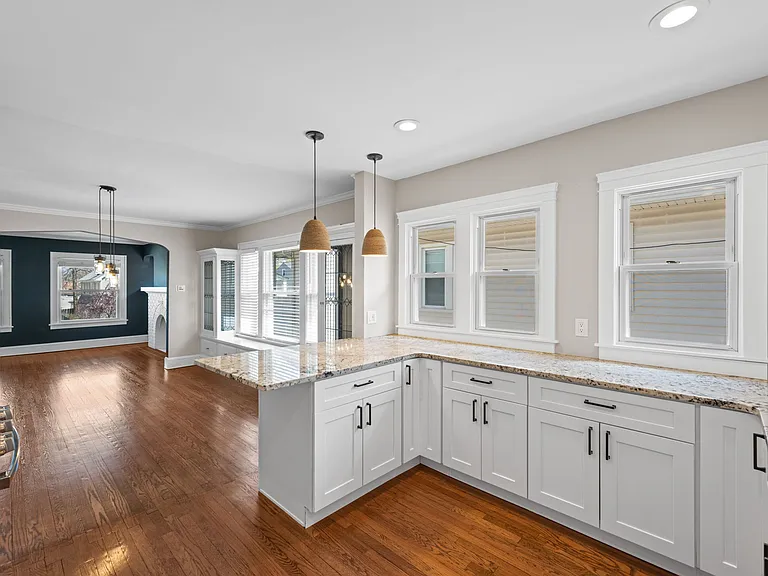 THis shows the wrap around cabinets, and how the kitchen leads to the dining room and living room beyond.